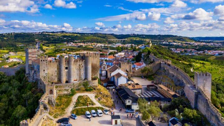 Vista de Óbido em Portugal, com casas brancas, árvores e castelo