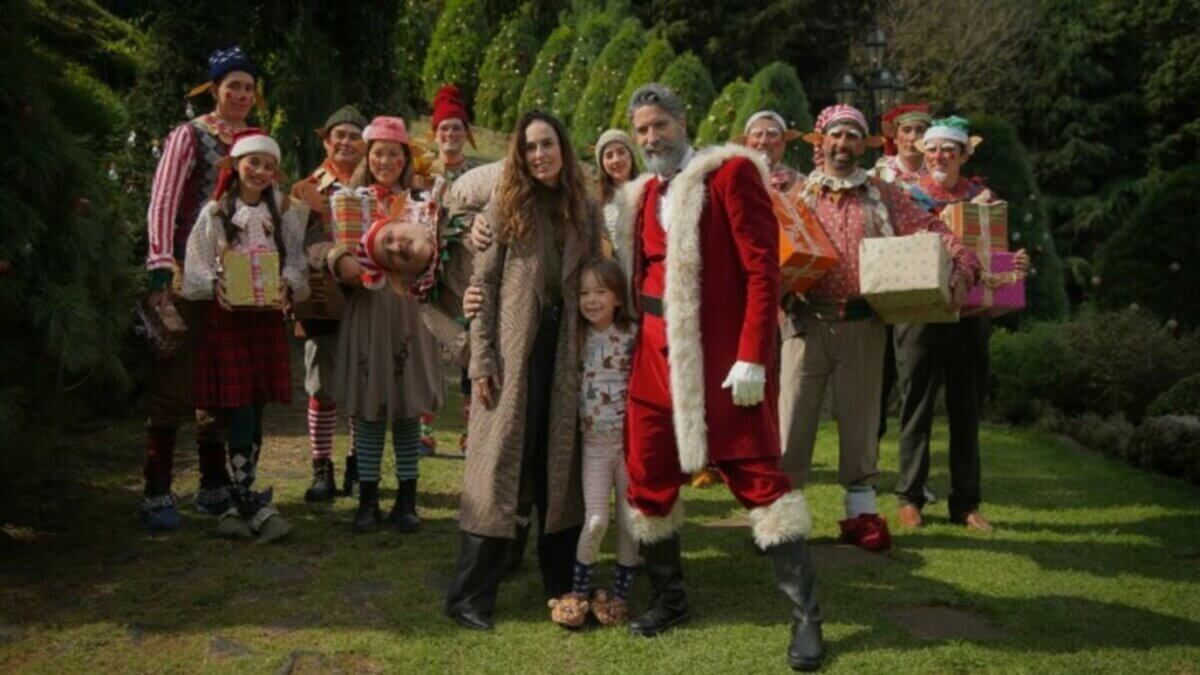 Cena do filme Dating Santa com diversos personagens natalinos em meio a árvores