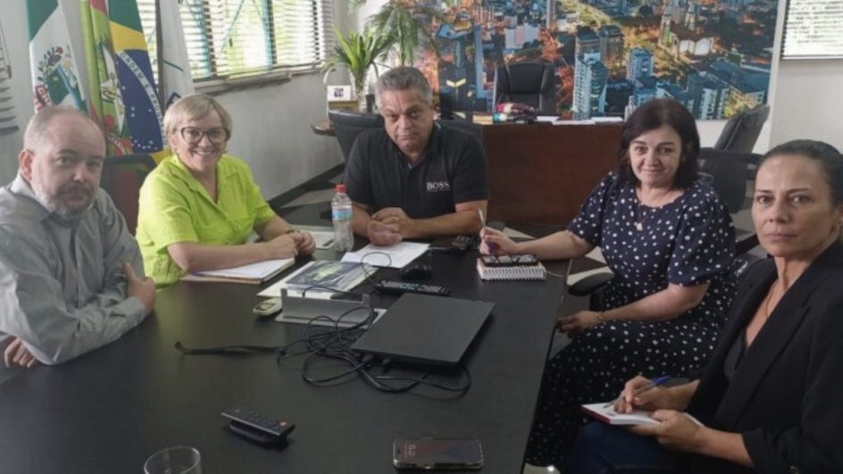 O prefeito, três mulheres e um homem sentados em uma mesa de reunião