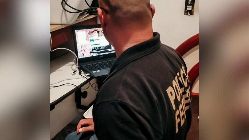 Policial utilizando computador do preso