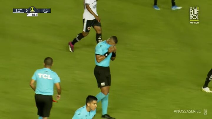 Momento em que o árbitro do jogo cobre os olhos por causa do gás de pimenta