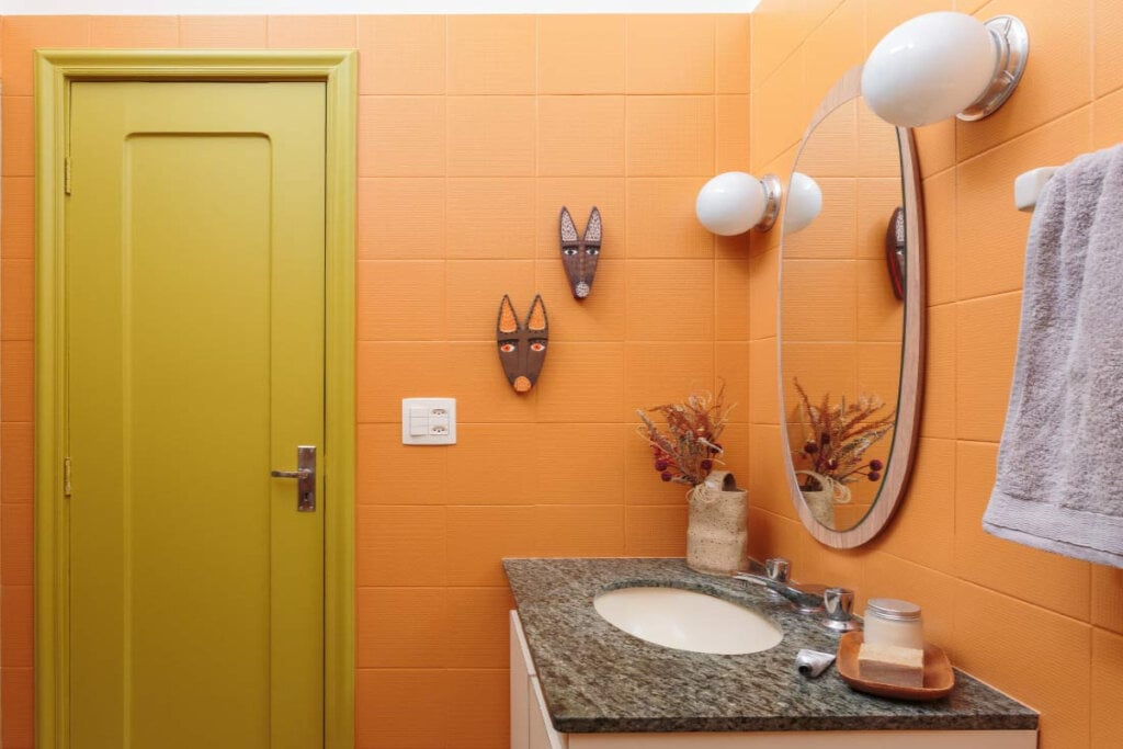 O banheiro ganha personalidade com paredes Calcita Alaranjada e uma porta Eclipse, criando um espa&ccedil;o en&eacute;rgico e &uacute;nico (Imagem: @_felco | Divulga&ccedil;&atilde;o Suvinil)