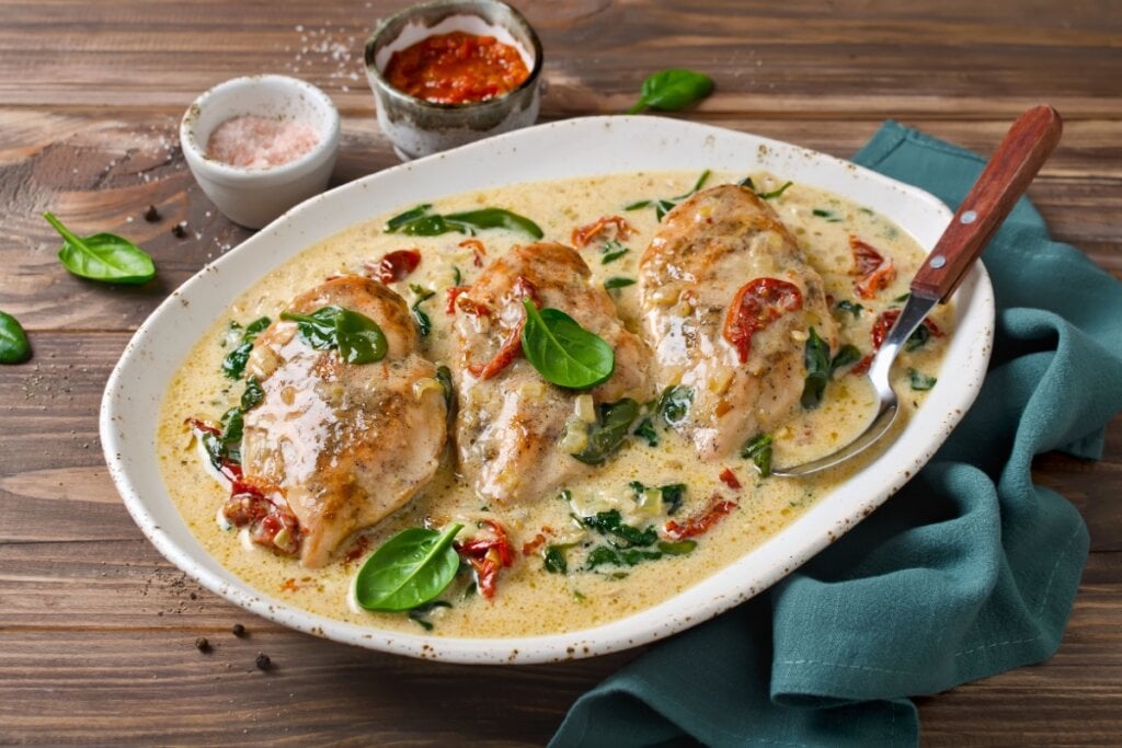 Frango ao molho de leite de coco com espinafre e tomate seco (Imagem: vkuslandia | Shutterstock)