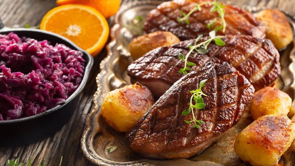 Peito de pato grelhado com batatas assadas e repolho roxo (Imagem: Marian Weyo | Shutterstock)