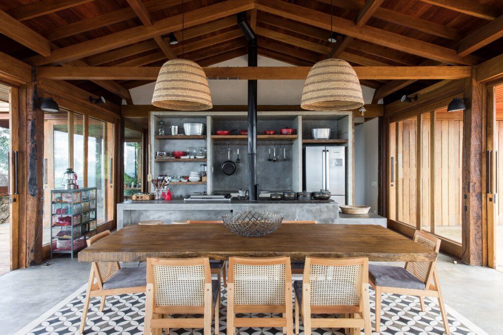 Na cozinha, a combinação de pedra e madeira nos móveis valoriza a decoração rústica (Imagem: Maíra Acayaba | Projeto: Sabella Arquitetura)