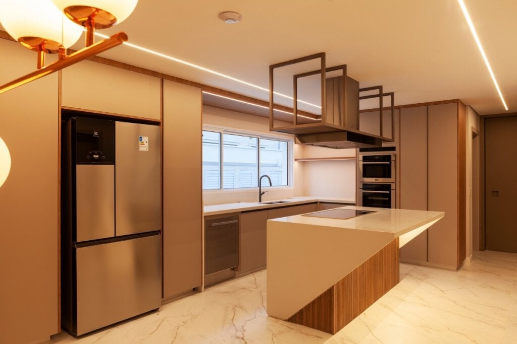 A ilumina&ccedil;&atilde;o desempenha um papel importante na composi&ccedil;&atilde;o da cozinha em &lsquo;L&rsquo; (Projeto: Infinity Spaces Arquitetura e Interiores | Imagem: Dotta Photo)