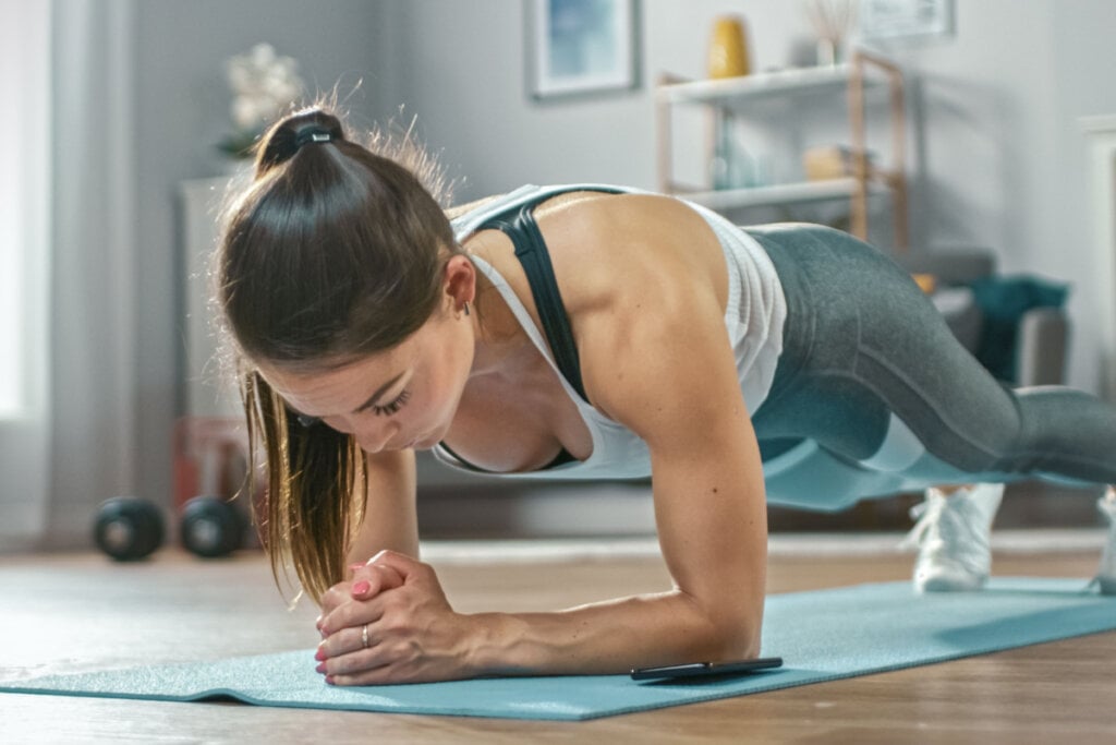 Na prancha no solo, o corpo deve estar alinhado e com o peso apenas nas pontas dos pés e antebraços (Imagem: Gorodenkoff | Shutterstock)