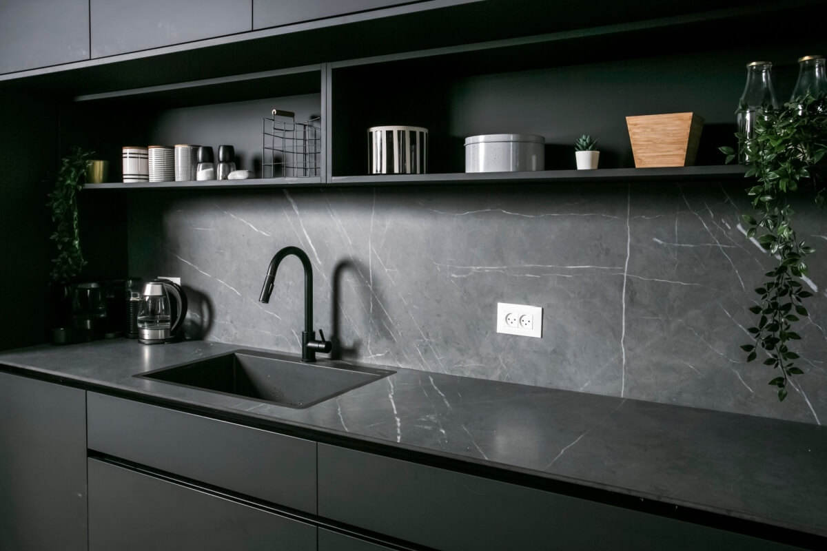 O uso do mármore escuro nas bancadas oferece durabilidade e um visual refinado em cozinhas (Imagem: Photographer Lili | Shutterstock)