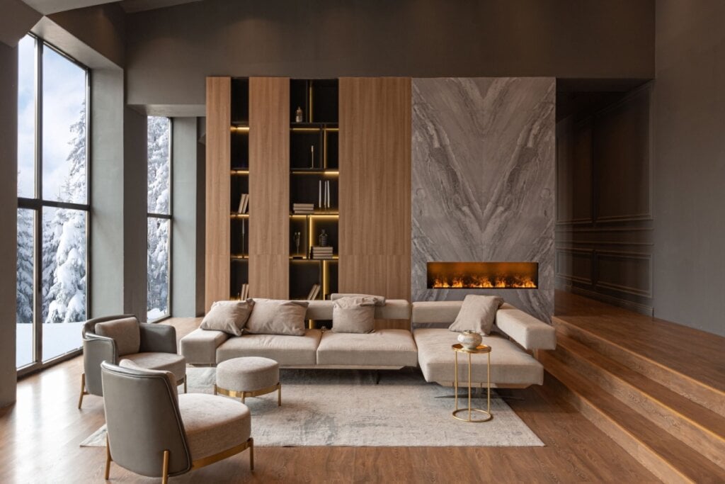 O mármore aplicado em áreas estratégicas da sala, como a parede da lareira, adiciona uma sensação de luxo discreto e sofisticado (Imagem: Pinkystock | Shutterstock)