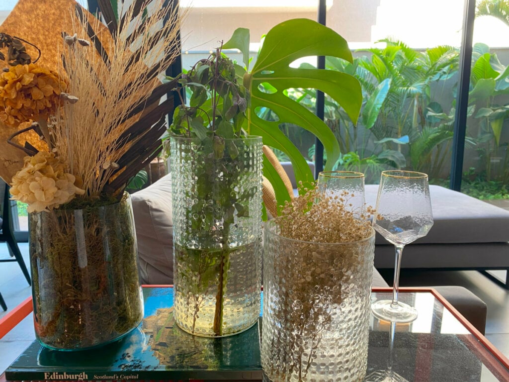 Itens que você já possui em casa, como potes de vidro e garrafas, podem ser transformados em porta-velas ou vasos charmosos (Imagem: Marina Mesquita)