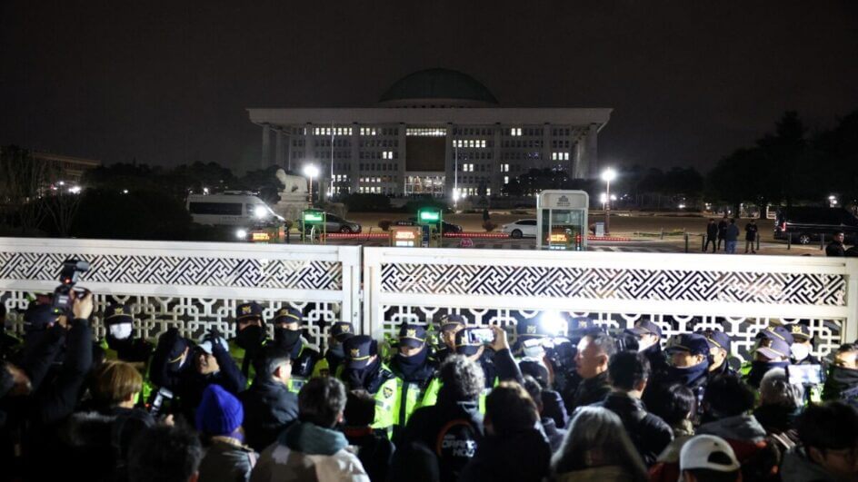 Policiais montam guarda no portão da Assembleia Nacional, depois que o presidente sul-coreano Yoon Suk Yeol declarou a lei marcial, em Seul, Coreia do Sul, 4 de dezembro de 2024. (Foto Kim Hong-Ji