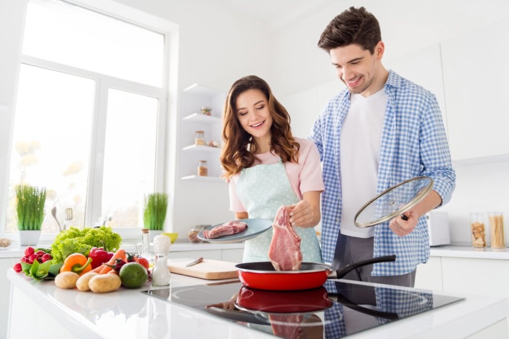Realizar o preparo das refeições em casal aumenta o vínculo e ajuda na organização alimentar (Imagem: Roman Samborskyi | Shutterstock)