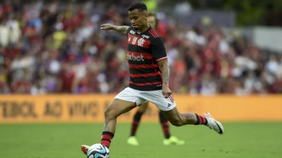 Imagem mostra Flamengo chutando bola e usando a camisa listrada do Flamengo em vermelho e preto