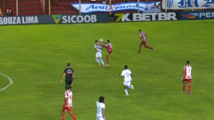 Imagem mostra jogador do Hercílio Luz vestido de uniforme vermelho e jogadores do Avaí de branco