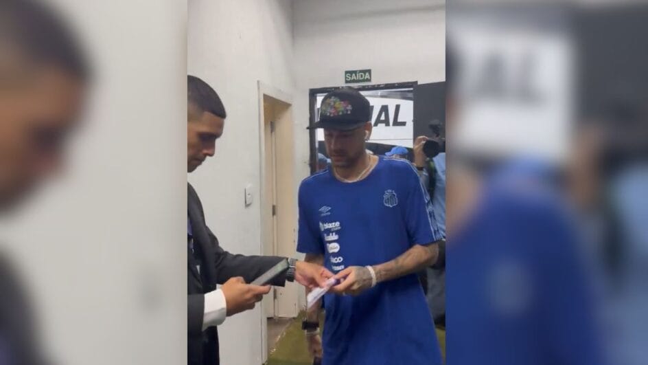 Neymar usando camisa azul de viagem do Santos e de boné