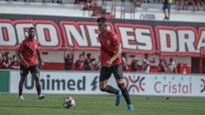 Imagem mostra jogador do Atlético-GO com a camisa vermelha e a bola na frente