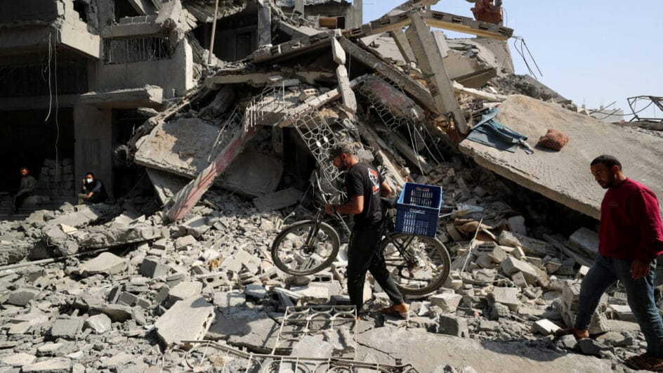 Palestinians inspect the site of an Israeli strike on a residential building in Jabalia