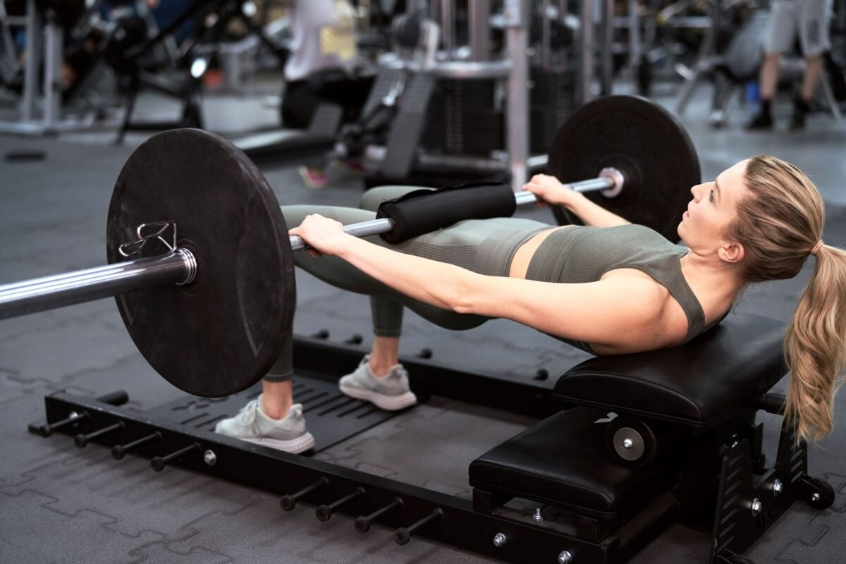 A elevação pélvica na máquina e com barra livre oferece vantagens diferentes para o corpo (Imagem: gpointstudio | Shutterstock)
