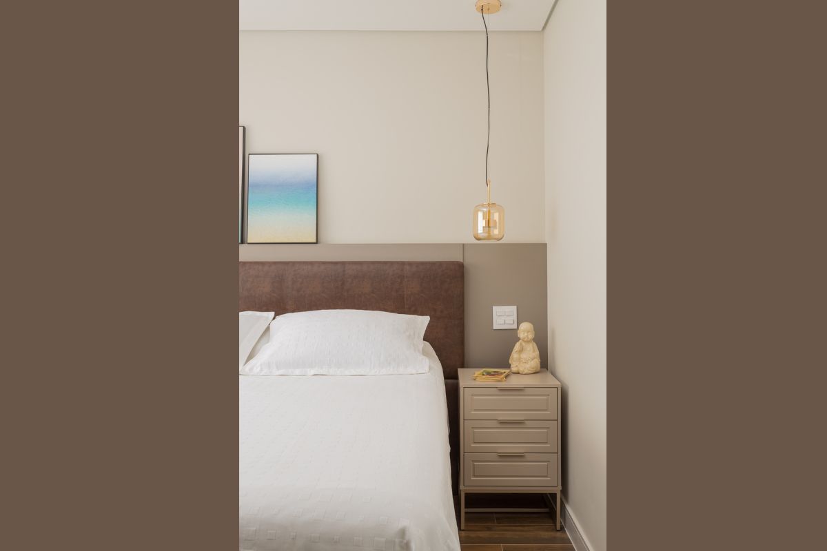 Cabeceira de couro marrom atrás de uma cama com lençol branco