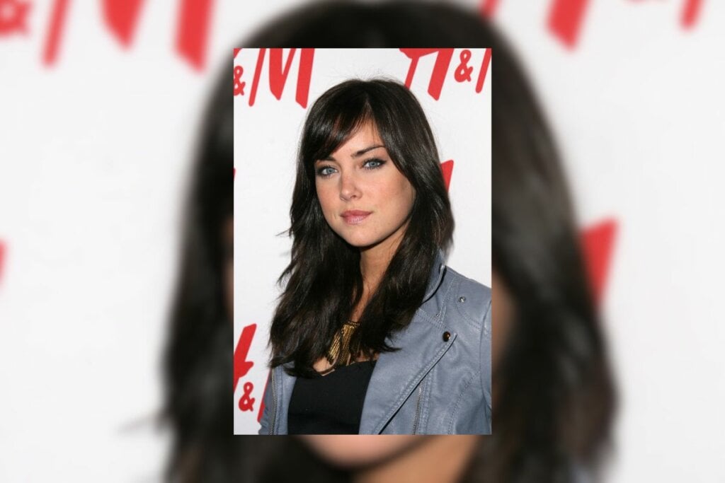 Mulher com cabelo longo e preto com franja diagonal posando para foto