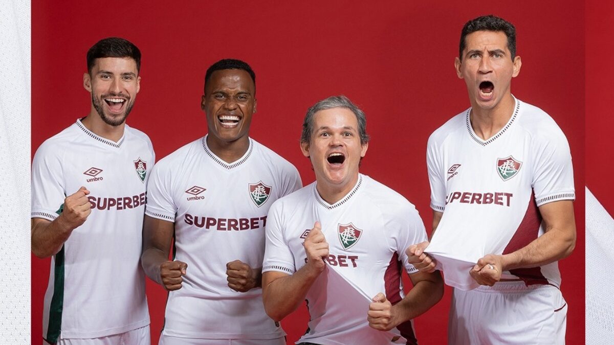Jogadores posando com torcedor presenteado pelo Fluminense - (Foto: Umbro e Lucas Merçon, FFC)