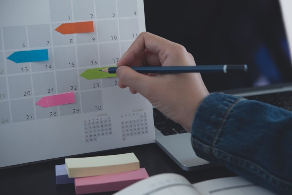 M&Atilde;&pound;o segurando um l&Atilde;&iexcl;pis e riscando um calend&Atilde;&iexcl;rio