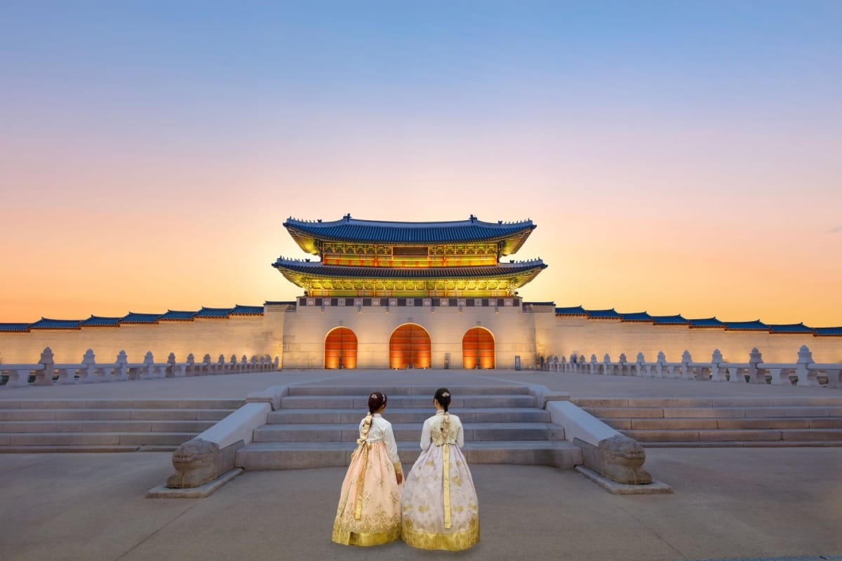Imagem do Palácio Gyeongbokgung iluminado por luzes amarelas no entardecer