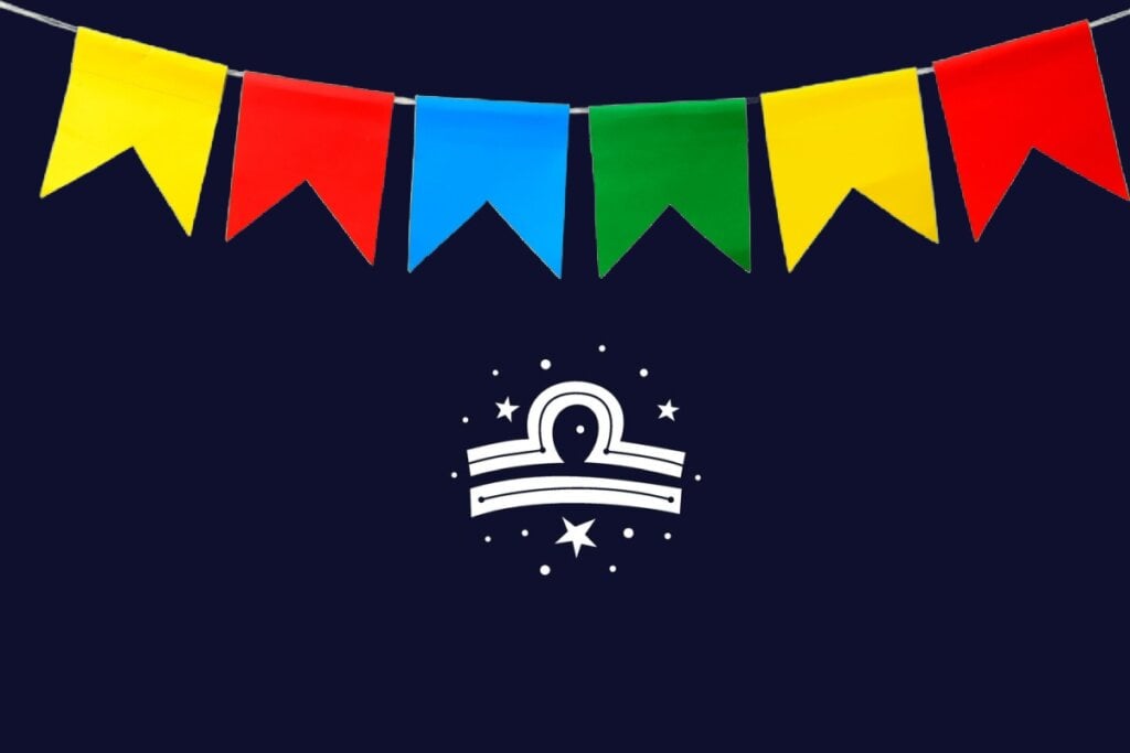 Ilustração do signo de Libra com semicÃrculo acima de duas linhas retas brancas, fundo azul-escuro e bandeirinhas vermelhas, azul, verde e amarelas