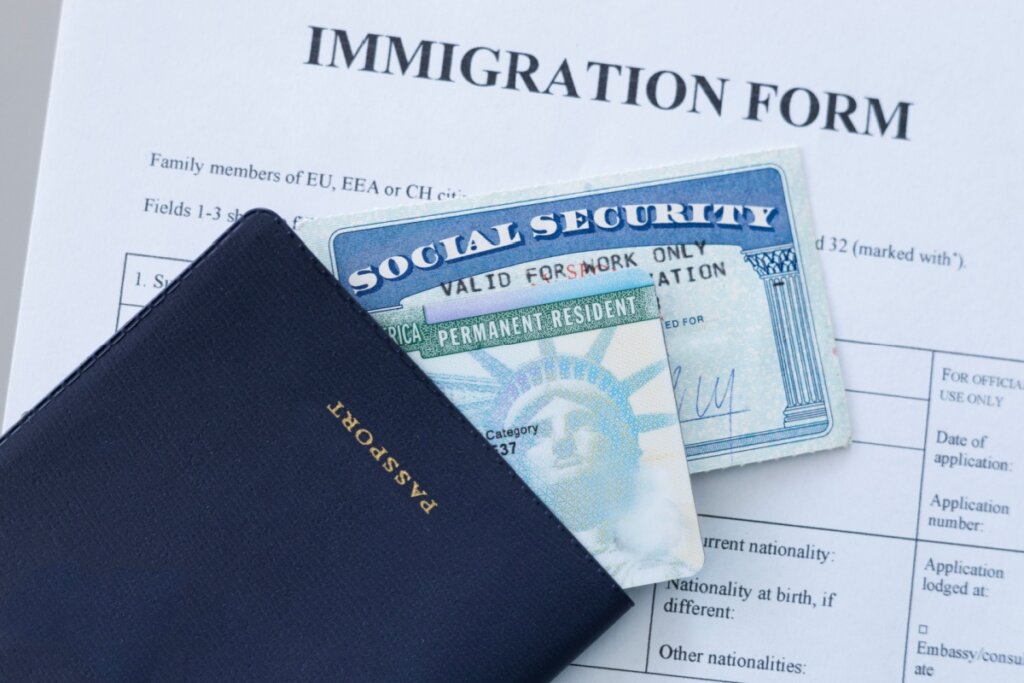 Formulário de imigração com um passaporte e green card em cima dele