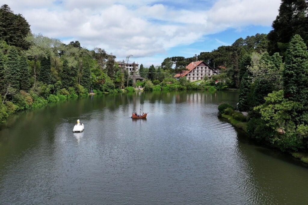 Vista do Lago Negro, rodeado por &Atilde;&iexcl;rvores e casas com arquitetura europeia em Gramado, RS