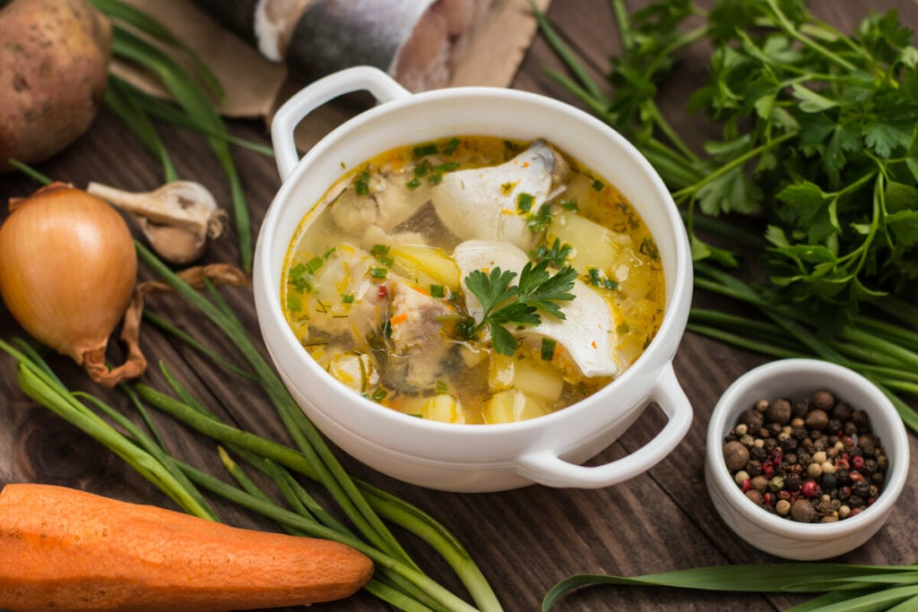 Panela branca com sopa de peixe e batatas