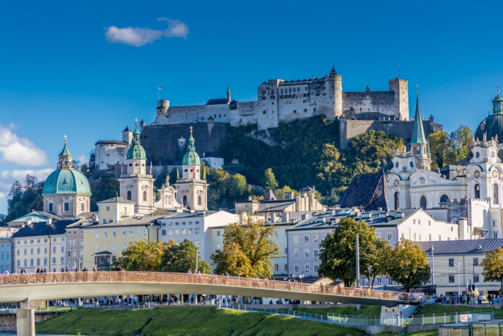 Imagem de um castelo no alto de uma montanha e rodeado por construÃ§Ãµes em Salzburgo
