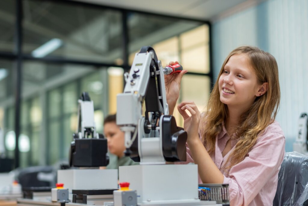 Menina em uma sala de aula mexendo em um robô