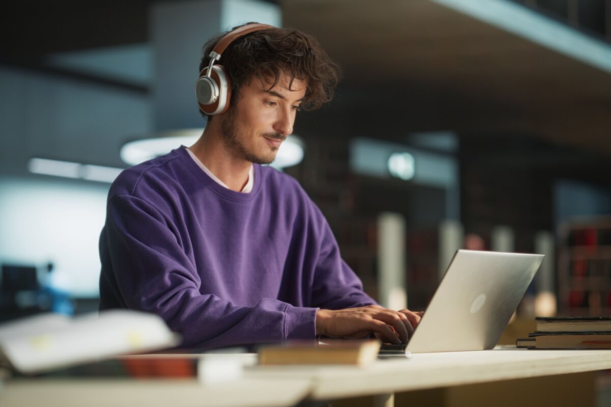 Jovem concentrado estudando em frente a um notebook e sentado