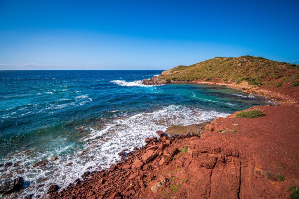 Praia com montes rochosos e água cristalina