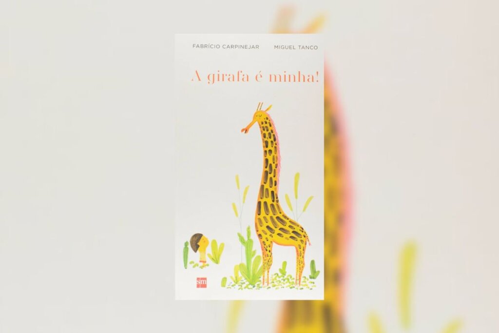 Capa do livro "A Girafa Ã© Minha!" coma ilustraÃ§Ã£o de uma crianÃ§a e uma girafa em um jardim