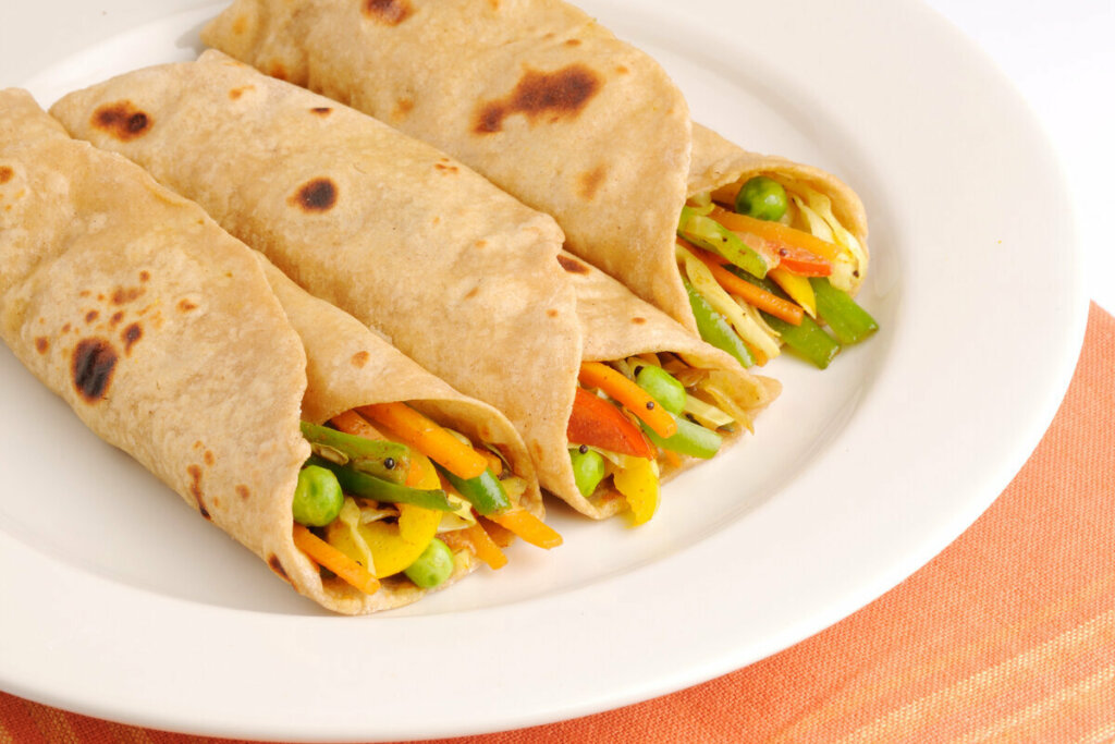 TrÃªs panquecas recheadas com legumes em um prato branco