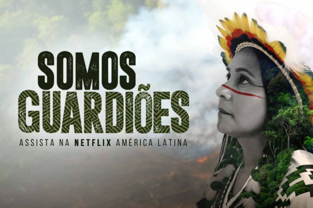 Capa do filme-documentário "Somos Guardiões" com a foto de uma mulher indÃgena sobre a imagem de uma floresta sendo devastada