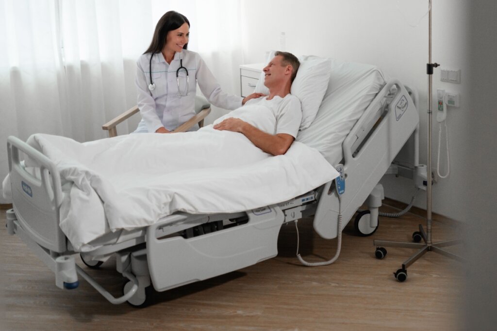 Médica conversando com paciente deitado em leito hospitalar