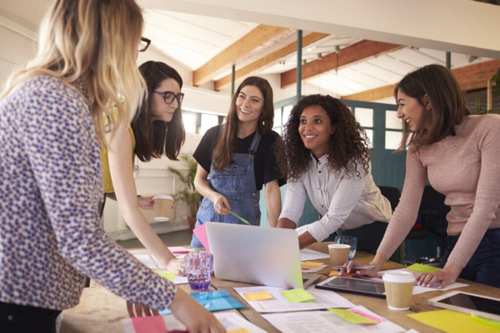 Mulheres em pé em uma sala de reunião e conversando