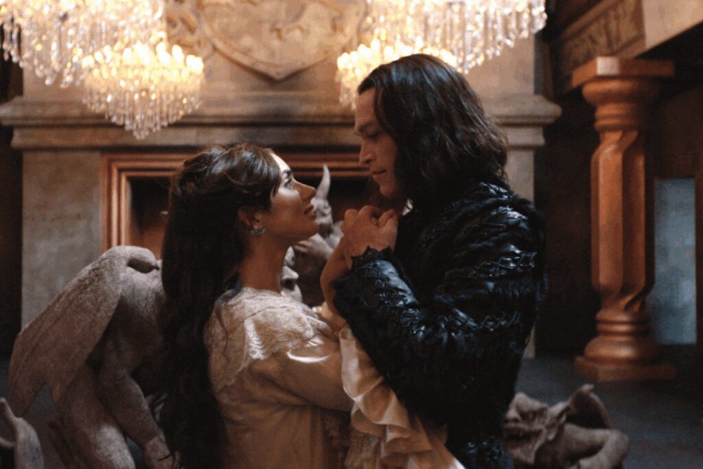 Casal danÃ§ando, ambos estÃ£o usando roupas de epoca, a mulher com roupas em tons claros e o homem usando roupas pretas