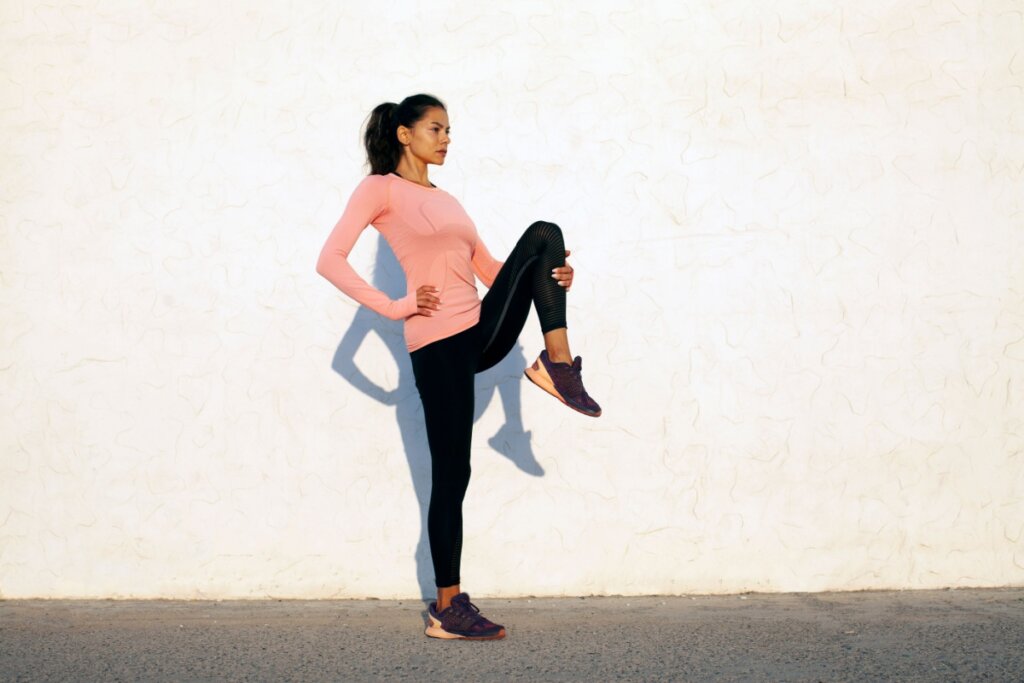 Mulher em p&Atilde;&copy; com uma das pernas levantada em dire&Atilde;&sect;&Atilde;&pound;o ao t&Atilde;&sup3;rax