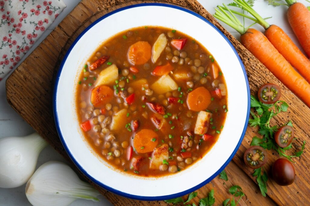 Prato branco com sopa de lentilha com cenoura e batata