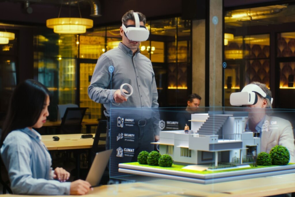 TrÃªs pessoas em uma sala, duas delas usando Ã³culos de realidade 3D, olhando para um projeto arquitetÃ´nico