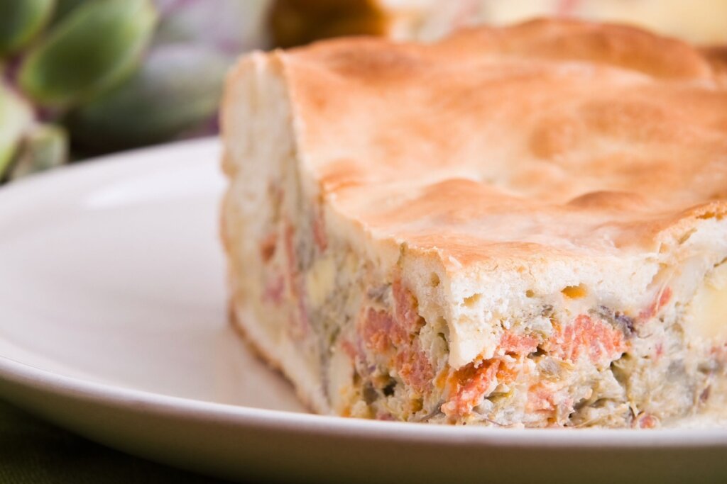 Prato branco com um pedaÃ§o de torta de alcachofra
