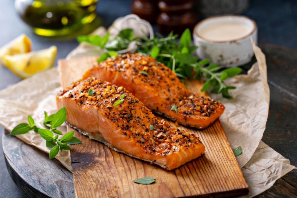 SalmÃ£o grelhado com ervas em tÃ¡bua de madeira