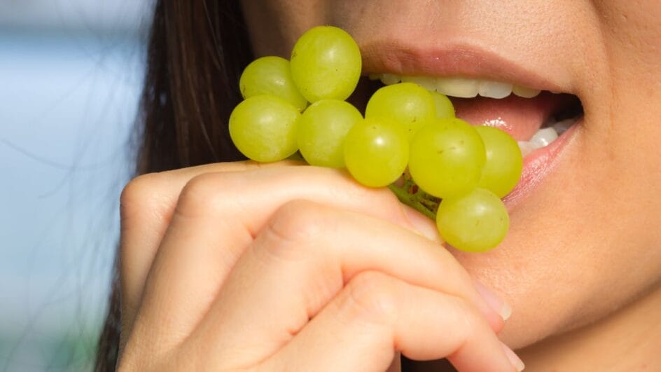 pessoa comendo uvas verdes