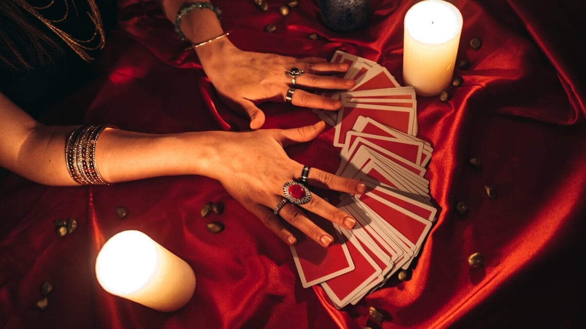 Mulher embaralha cartas de baralho sobre fundo vermelho