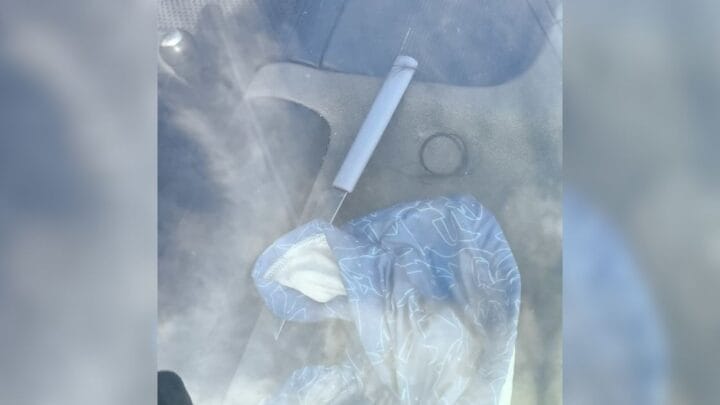 Faca usada por suspeito para cortar cabelo de mulher. Objeto com cabo branco está em superfície e coberta por um pano