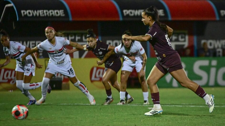 Jogadora do Ferroviária em cobrança de falta pelo time enquanto demais atletas esperam pela disputa de bola